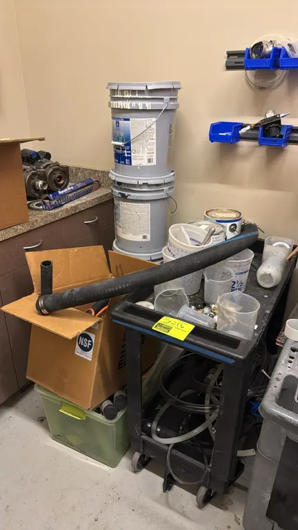 Poly 2-tier utility cart. 30" x 18". Mounted on casters. Includes assorted contents, plastic storage tub, cardboard box, rubber and poly hoses, pipe f