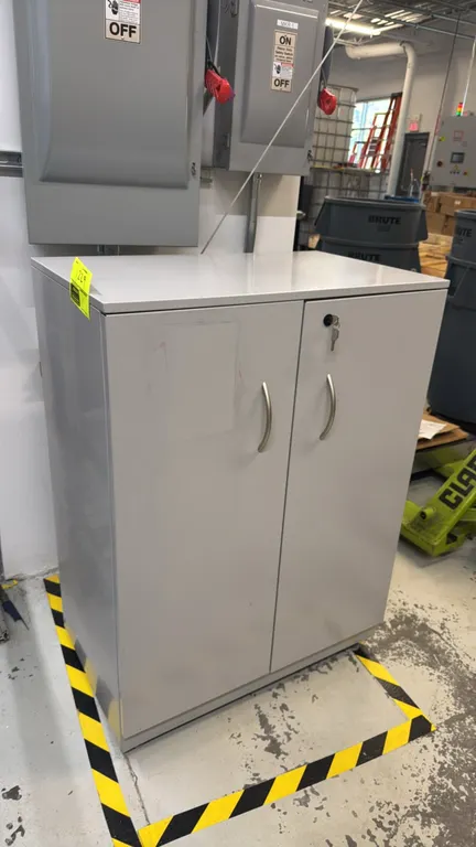2-door metal storage cabinet. Features locking double doors with key, bow pull handles, and two adjustable interior shelves. 30" x 18" x 41". Contents