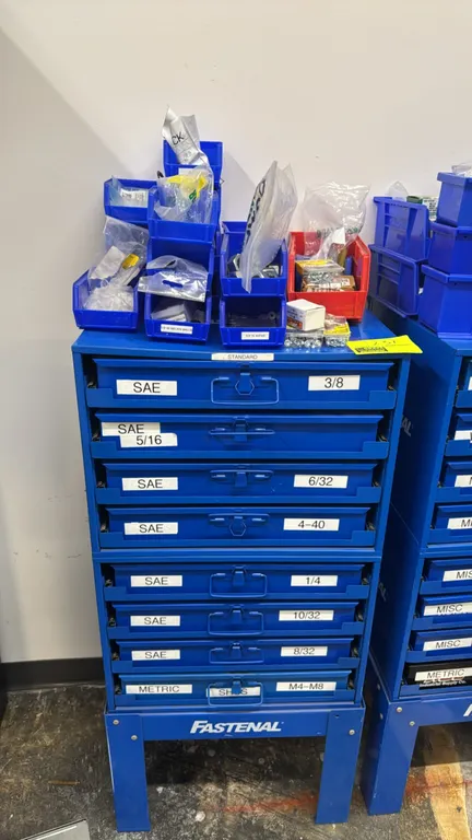 Fastenal 8-drawer metal hardware storage cabinet. Features 8 slide-out compartmentalized drawers containing assorted SAE and metric fasteners, socket