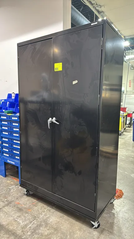 Uline 2-door metal mobile storage cabinet. Features dual locking swing doors and interior adjustable shelving. 4' x 2' x 7'. Mounted on swivel casters