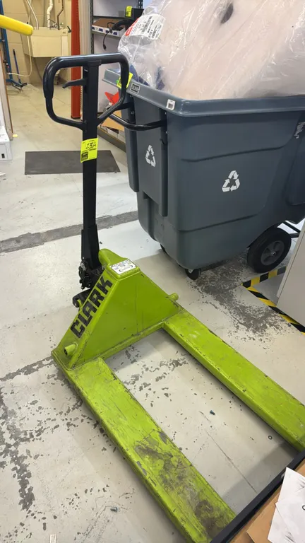 Clark CJ55 manual hydraulic pallet jack. Features a 5,500 lb (2,500 kg) load capacity, hydraulic lift pump, dual polyurethane steer wheels, and loop h