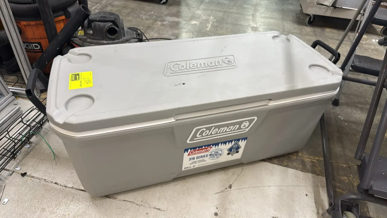 Coleman 316 Series 150-quart chest cooler. Features an insulated lid with integrated cup holders, swing-up side carry handles, and a capacity of up to