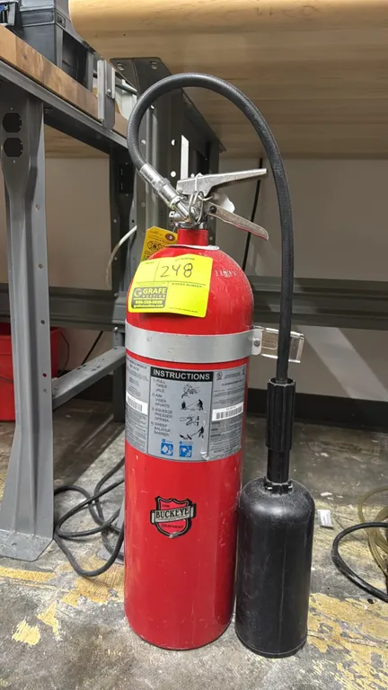 Buckeye 461 15 CD 15 lb CO2 fire extinguisher. Features discharge hose and horn assembly, squeeze lever with pull pin, and mounting bracket collar.
