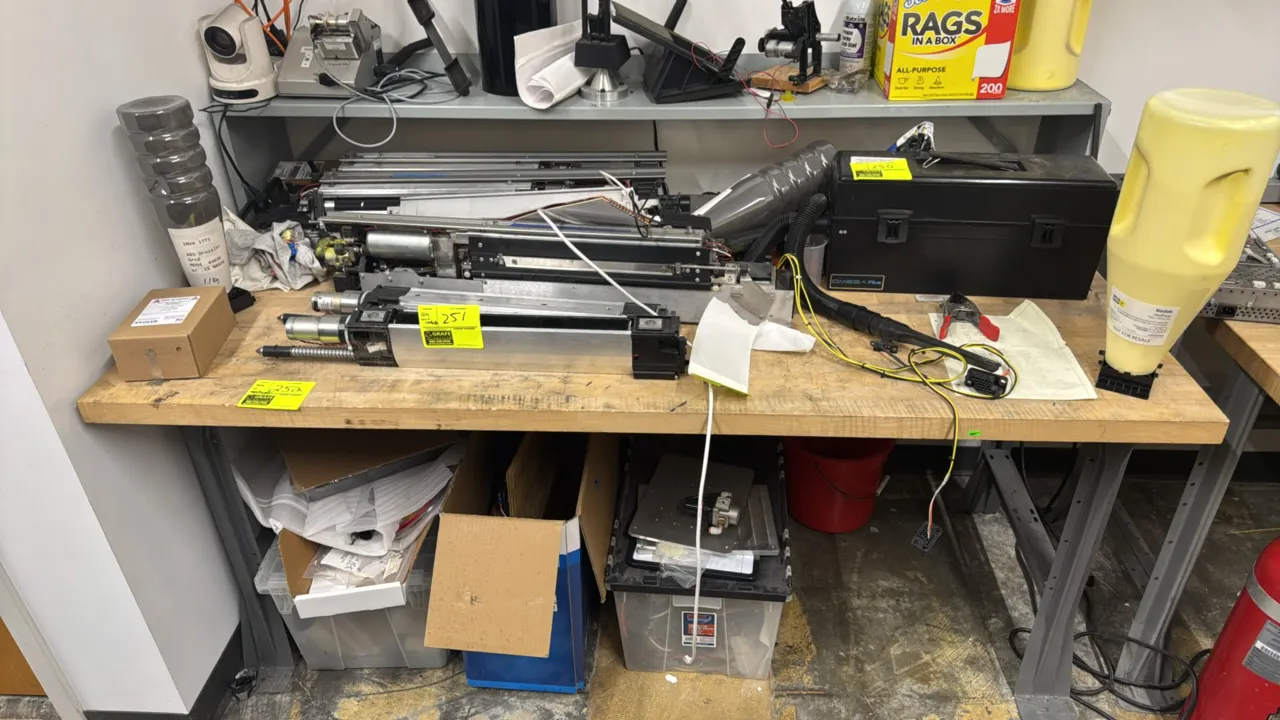 Metal workbench with wood top. Features a solid wood top mounted on a painted metal frame with support legs. 6' x 3'. Contents not included.