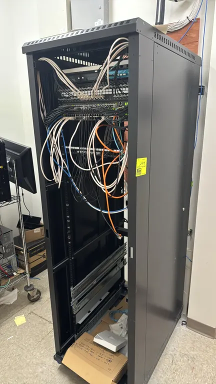 Metal IT server cabinet. Includes (2) Dell N2048P network switches and Leviton patch panels. Features internal mounting rails and ventilated panels. 2