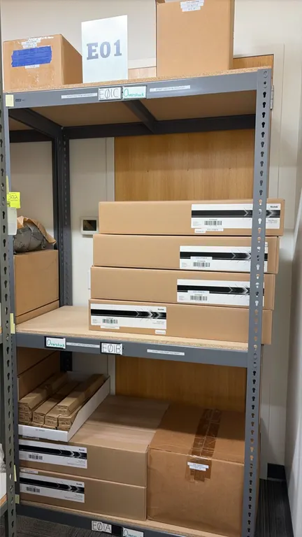 Light-duty storage racking with Kodak NexPress supplies. Features gray metal frame and composite wood decking. 48" x 24" x 84". Includes imaging cylin