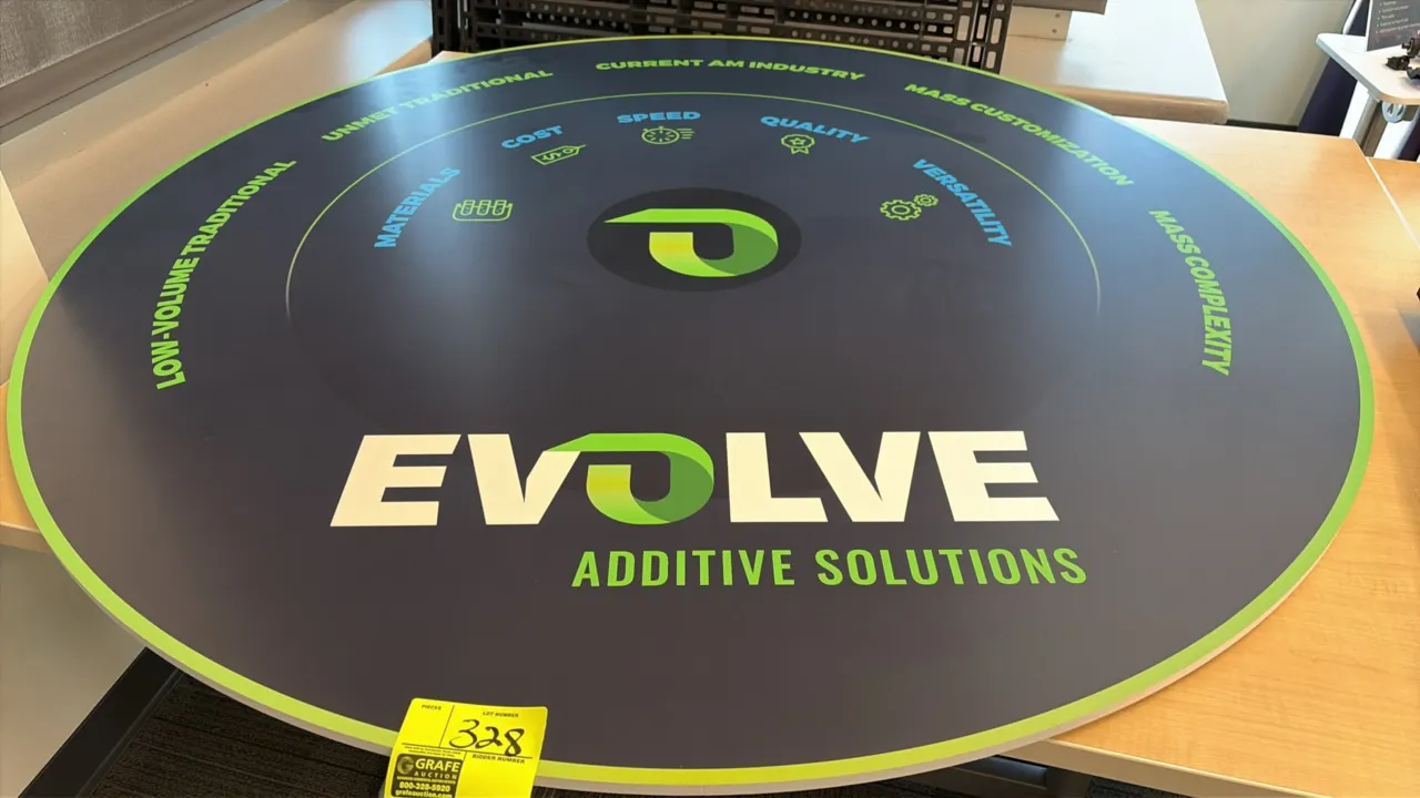 Evolve Additive Solutions circular graphic display sign. Features branded infographic design detailing additive manufacturing solutions. 60" Dia.