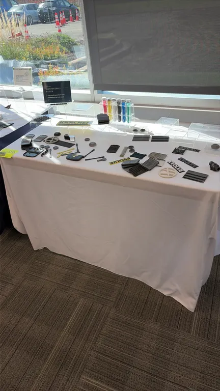Assorted trade show booth molded sample parts with Lifetime polyethylene folding banquet table. Lot includes various molded emblems, test specimens, t