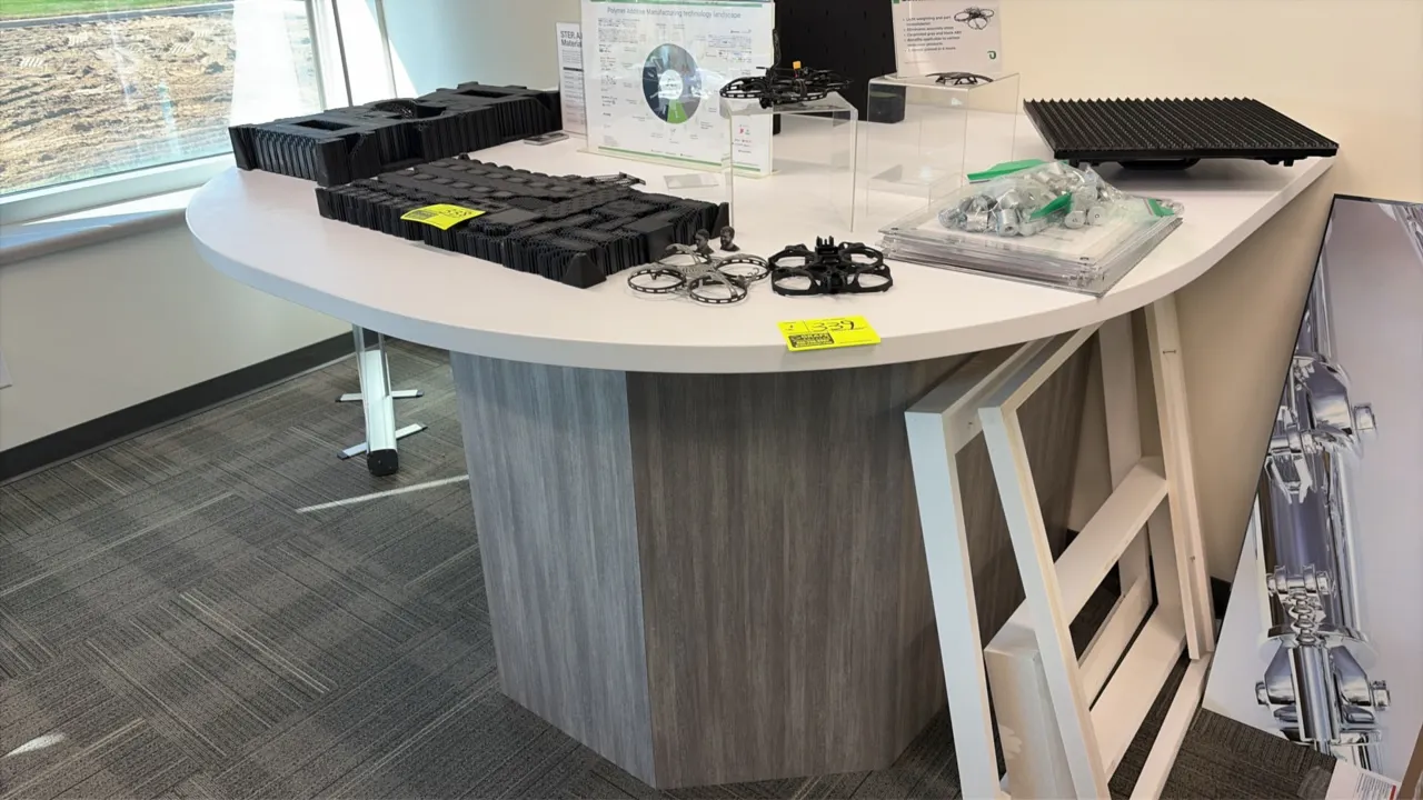 Half moon display table. Features a white laminate top and gray woodgrain laminate pedestal base. Dimensions: 72" x 60". Contents not included.