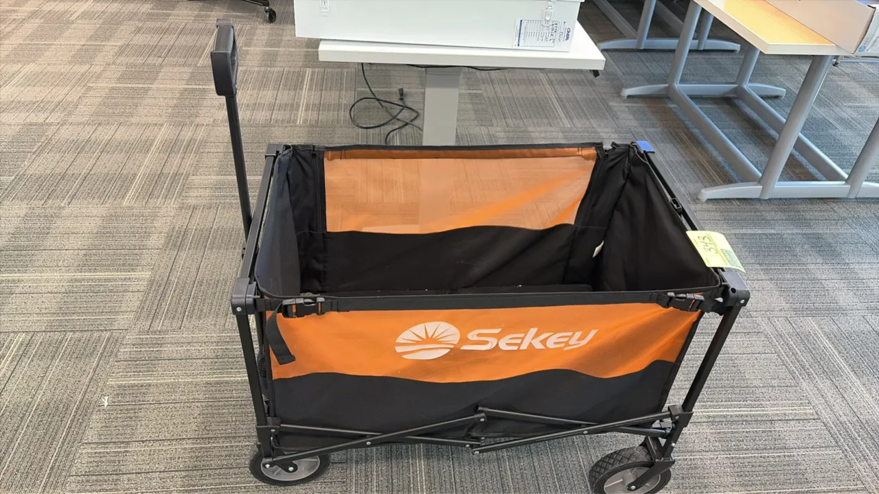 Sekey collapsible utility wagon. Features black and orange fabric liner, folding metal frame, telescoping pull handle, dual front mesh pockets, and fo