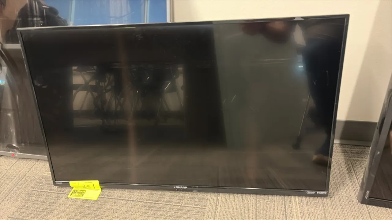 Sharp LC-39LE551U flat screen TV. Features HDMI and Dolby Audio support. S/N: 40500214784. Electrical: 120V, 60 Hz, 75W. Note: Remote control and base