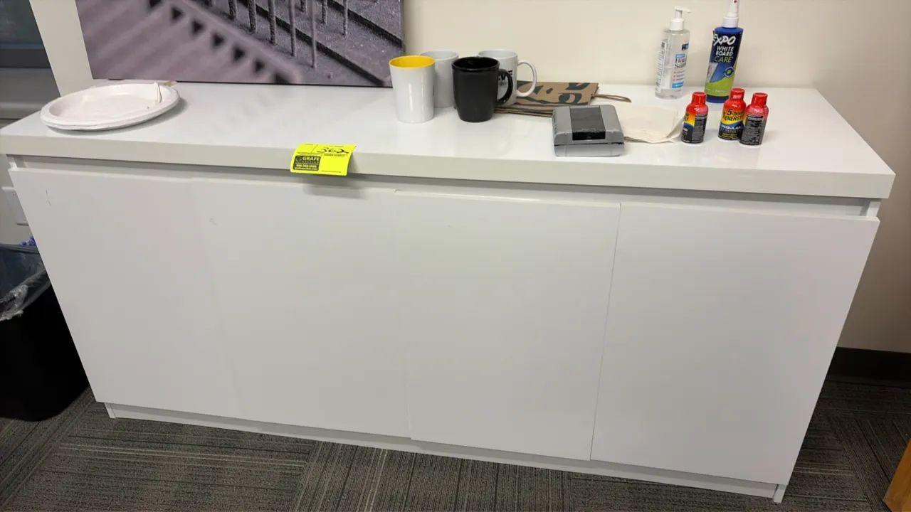 Wood laminate credenza. Features a white finish, (4) hinged cabinet doors, and divided interior storage shelving. 72" x 17 1/2". Contents not included