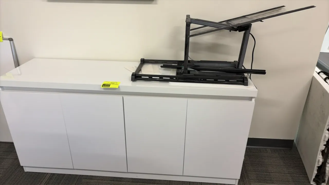 Wood laminate credenza with TV stand. Features a white finish, (4) cabinet doors, and divided interior storage shelving. Includes TV mount assembly. 7