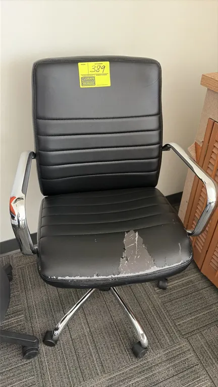 Office chair. Features black ribbed vinyl upholstery and chrome arms. Mounted on a chrome 5-star base with casters. Note: Seat upholstery is torn and