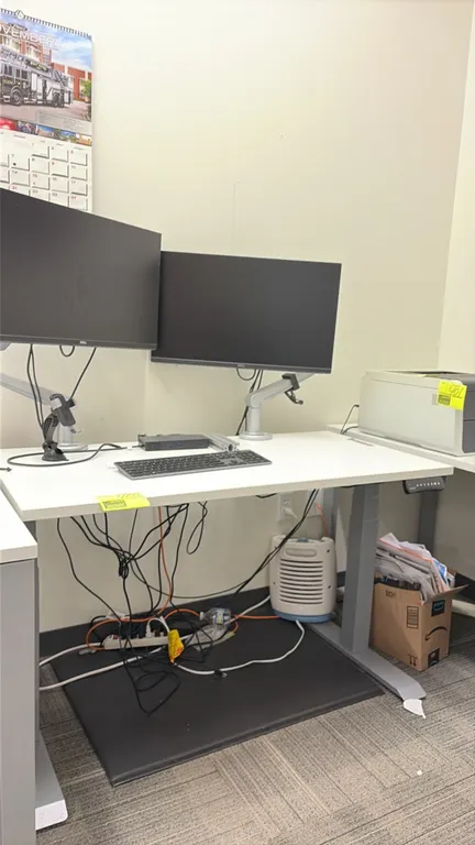 Electric height-adjustable sit-stand workstation with (2) 24" Dell monitors. Features a white wood laminate top and programmable push-button digital h
