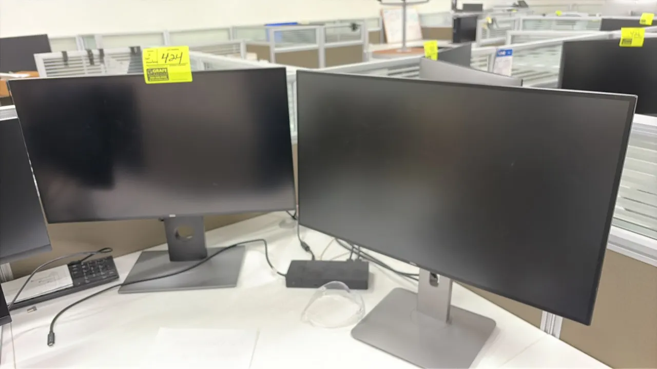 Dell 24" computer monitors. Features widescreen displays with slim bezel design. Mounted on adjustable desk stands.