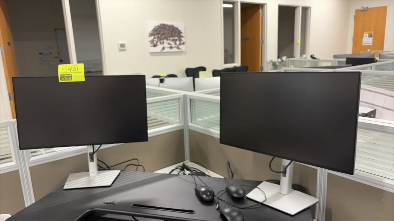 Dell 24" computer monitors. Features slim bezel flat-panel displays. Mounted on adjustable silver-tone desktop stands with cable management. Desk, com