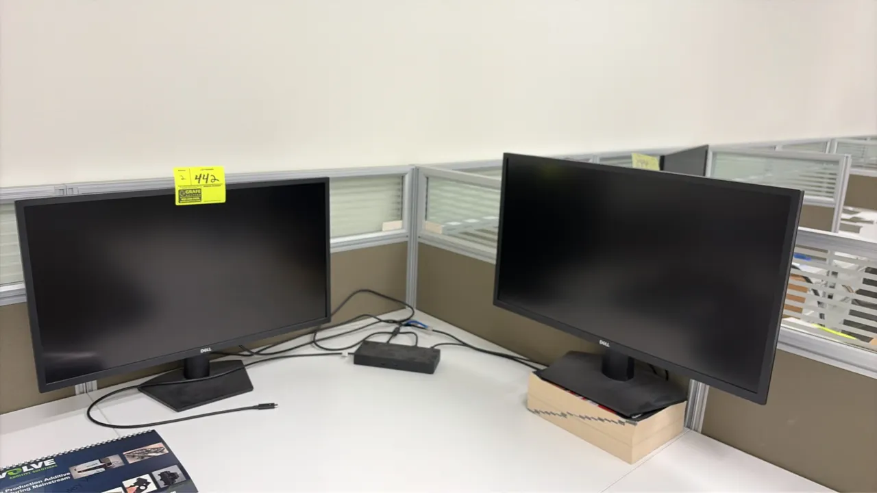 Dell 24" computer monitors. Features black finish and slim bezels. 24". Mounted on desktop stands. Desk, riser, and surrounding items not included.