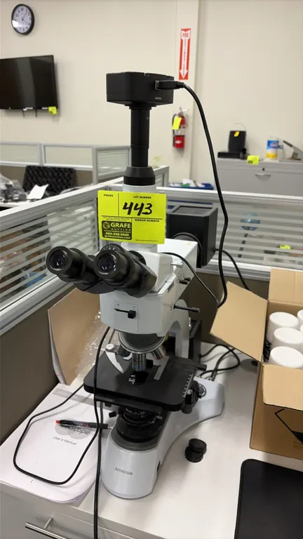 AmScope ME520 Series trinocular microscope. Features top-mounted digital camera with USB connectivity, revolving objective nosepiece with Plan 50x/0.7