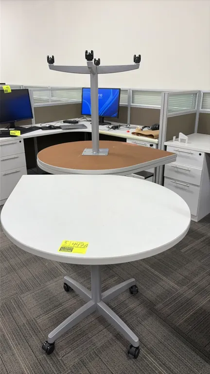 Teardrop portable work tables. Features wood laminate tops. 44" x 36". Mounted on silver-tone metal pedestal bases with casters.