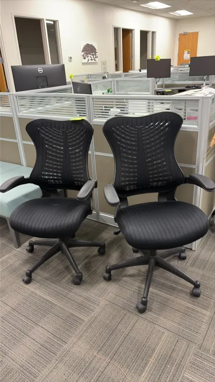 Mesh office task chairs. Features black mesh back and seat, integrated armrests, and black frame. Mounted on a 5-star swivel base with rolling casters