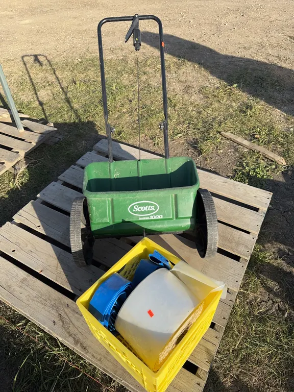 Scotty spreader w/ crate of lay flat hose and a roll of poly