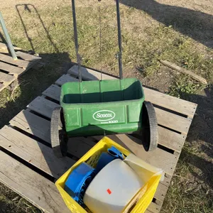 Scotty spreader w/ crate of lay flat hose and a roll of poly