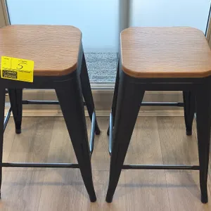 2023 LumiSource stools. Features woodgrain laminate tops and black metal frames with integrated footrests. 24"H.