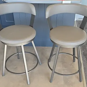 2022 Hong Van swivel stools. Features gray faux leather upholstered padded seats and curved backrests, swivel mechanism, and metal frames with integra