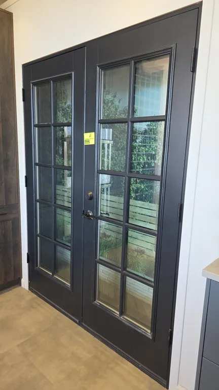Set of French doors. Features a 10-lite glass pane design on each door with a dark gray finish. Includes Defiant lever handle and deadbolt hardware an