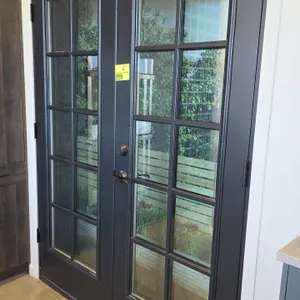 Set of French doors. Features a 10-lite glass pane design on each door with a dark gray finish. Includes Defiant lever handle and deadbolt hardware an
