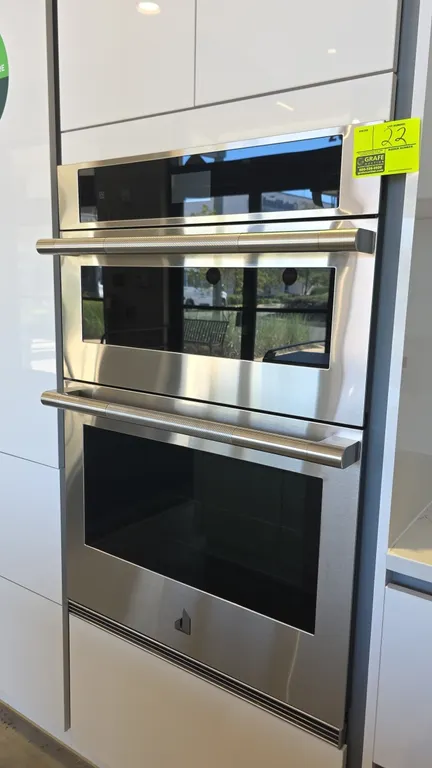 2023 JennAir JMW2430LL03 30" built-in combination wall oven. Features stainless steel finish with glass door panels, knurled bar handles, digital touc
