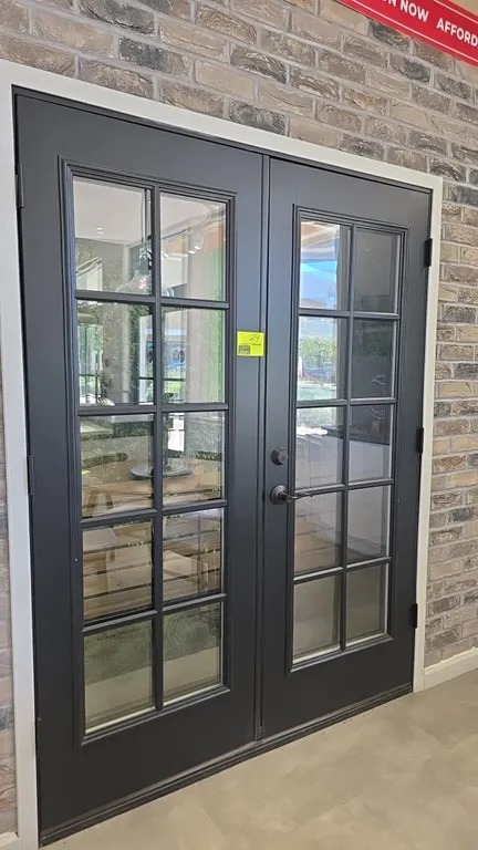 Set of French doors. Features a 10-lite glass pane design on each door with a dark gray finish. Includes Defiant lever handle and deadbolt hardware. 6