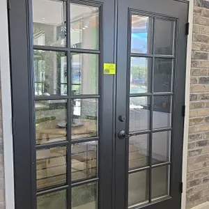 Set of French doors. Features a 10-lite glass pane design on each door with a dark gray finish. Includes Defiant lever handle and deadbolt hardware. 6
