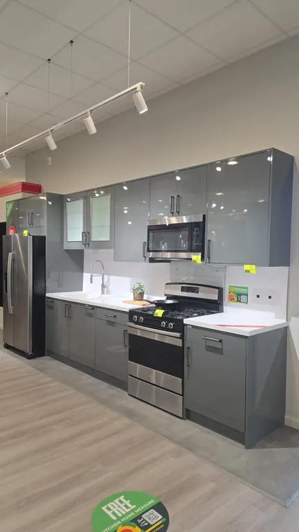 Infinity Plus upper and lower kitchen cabinets. Features gray high-gloss finish, solid surface countertops with matching backsplash, single-basin sink