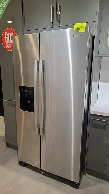 2022 Amana ASI2575GRS08 side-by-side refrigerator and freezer. Features a stainless steel finish, exterior door ice and water dispenser, interior glas