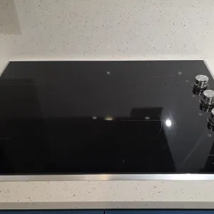 JennAir JEC3430HS00 30" electric cooktop. Features black ceramic glass surface with stainless steel trim, 4 radiant heating elements, and side-mounted