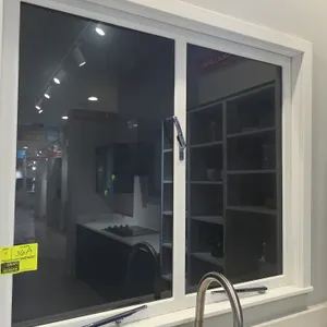 Casement windows. Features white frame, clear glass panes, and chrome locking latches and bottom stay bars. Countertop, faucet, and background items n