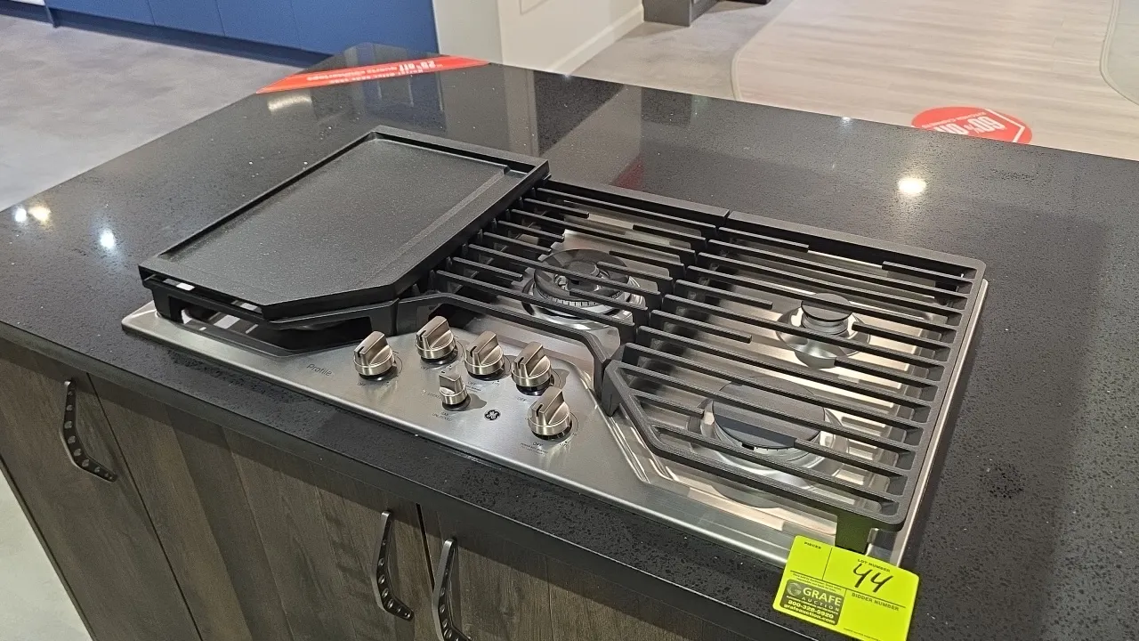 GE Profile PGP9036SL2SS 5-burner natural gas cooktop. Features stainless steel finish, continuous cast iron grates, and control lock. Includes 12" x 1