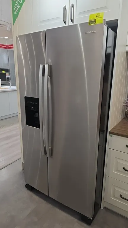2022 Amana ASI2575GRS08 side-by-side refrigerator and freezer. Features stainless steel finish, exterior door water and ice dispenser, integrated auto