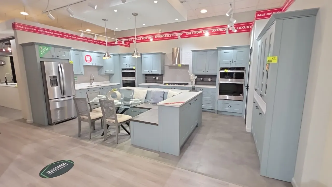 Infinity Plus L-shape kitchen cabinet set. Features upper and lower cabinets, solid surface countertops, stainless steel double-basin sink with faucet