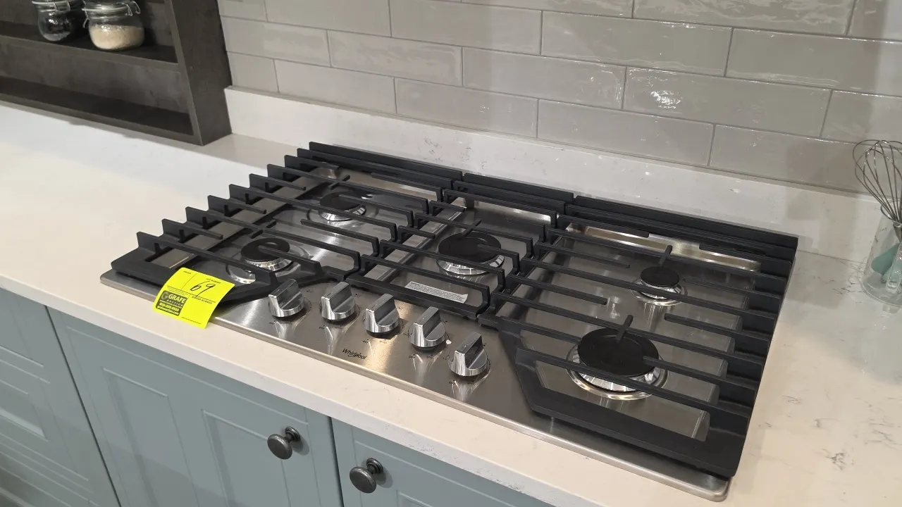 Whirlpool WCG55US6HS00 36" built-in 5-burner natural gas cooktop. Features stainless steel finish, continuous cast iron grates, front control knobs, a
