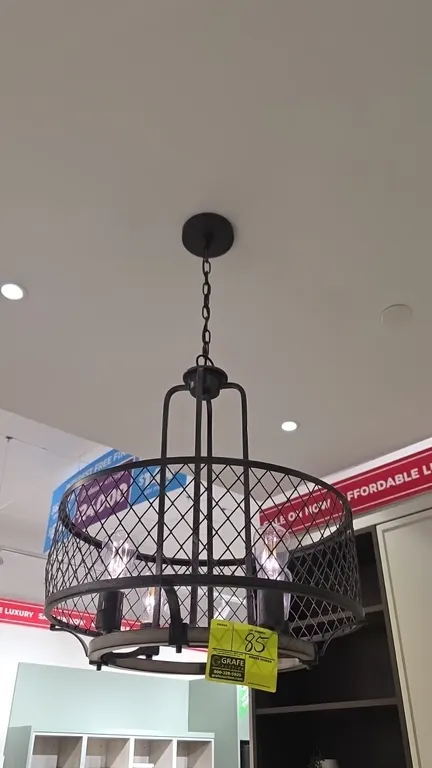 Metal pendant light fixture. Features an industrial wire mesh drum shade with wood-tone lower accent ring, 4-light design, hanging chain, and ceiling