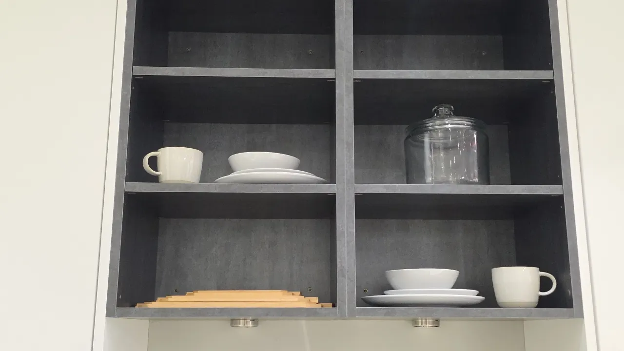 Assorted kitchen display smallwares. Includes ceramic dinner plates, bowls, and mugs, stainless steel flatware, wooden rolling pin with caddy, white c