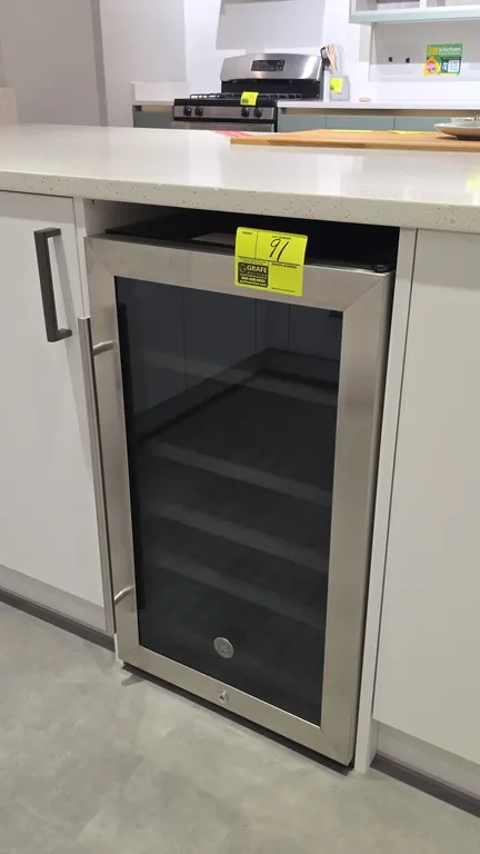 General Electric GVS04BQNCSS built-in wine refrigerator. Features stainless steel framed glass door, digital temperature controls, and wooden slide-ou