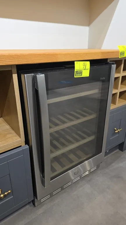 GE Profile PVS06BSPBSS undercounter wine refrigerator. Features stainless steel trim, glass door, wood-front slide-out racks, and digital touch contro