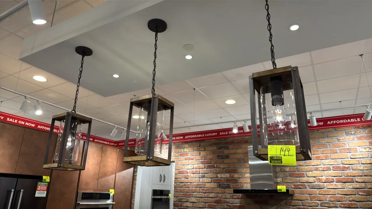 Hanging light fixtures. Features rustic wood and dark metal open-cage frames, cylindrical clear glass shades, and chain suspensions with ceiling canop