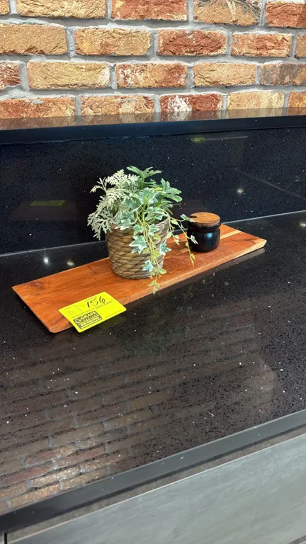 Assorted tabletop display smallwares. Includes rectangular wood serving board, (2) artificial potted plants, and black canisters with wood lids.