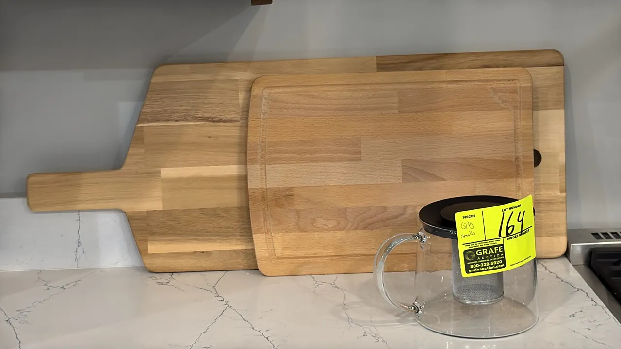 Assorted kitchen and decorative smallwares. Includes (2) wood cutting boards, (1) glass tea infuser pitcher, (1) ceramic serving bowl with (2) wooden