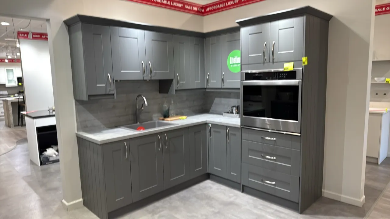 Infinity Plus kitchen cabinets with laminate countertops, sink, and pull-down faucet. Features gray finish cabinetry with upper and lower units and ta
